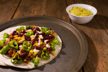 Mexican tortillas with meat, red beans, Jalapeno pepper and salsa guacamole