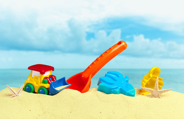 Fototapeta na wymiar Plastic children toys on the sand beach