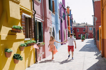 Beautiful couple walking holding hands in Burano, Venice, Italy