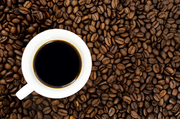 top view of cup of hot coffee and coffee bean in the background