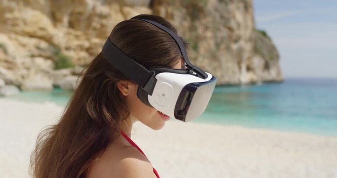 Sexy Young woman on tropical beach wearing virtual reality headset watching 360 travel video imagination concept enjoying summer vacation