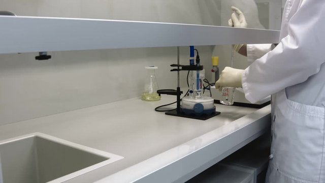 Analytical laboratory. Mixing of the solution. Adding substance to the solution. Adding a transparent reagent.