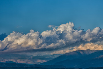 Cumulus clouds moving over mountains