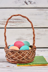 Easter basket and napkins. Pile of colorful chicken eggs.