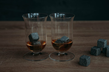 Stones for cooling whiskey and glases tulup on dark wooden background