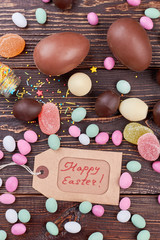 Happy Easter tag and sweets. Top view of scattered candies.