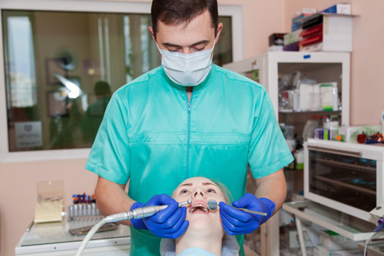 Dentist is treating teeth for a woman