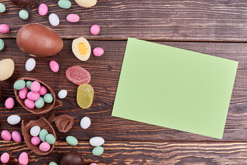 Sweets and card with copyspace. Scattered candies on wood.