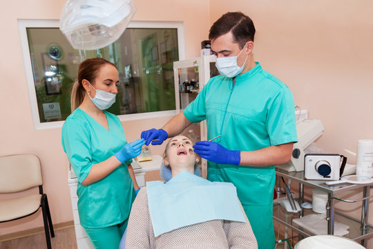 Two dentists are treating a patient