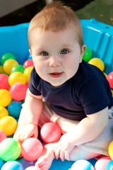 Fototapeta na wymiar cute little baby boy having fun in ball pit