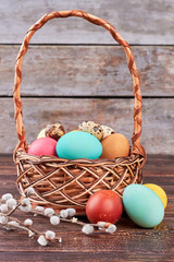 Willow branches and dyed eggs. Wicker Easter basket.