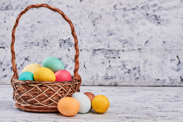 Basket and eggs on wood. Pile of dyed eggs. Celebrating Easter around the world.