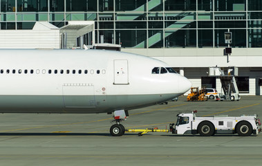 TUG Pushback tractor with Aircraft on the runway in airport.