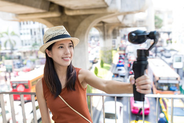 Woman using video camera for taking video in Bangkok city