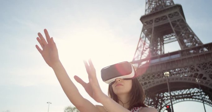 Tourist woman Eiffel tower Paris wearing virtual reality headset  watching 360 video imagination concept at sunset