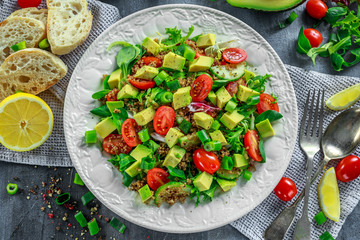 Quinoa tabbouleh salad with avocado, tomatoes, cucumber, green onion. Concept healthy food.