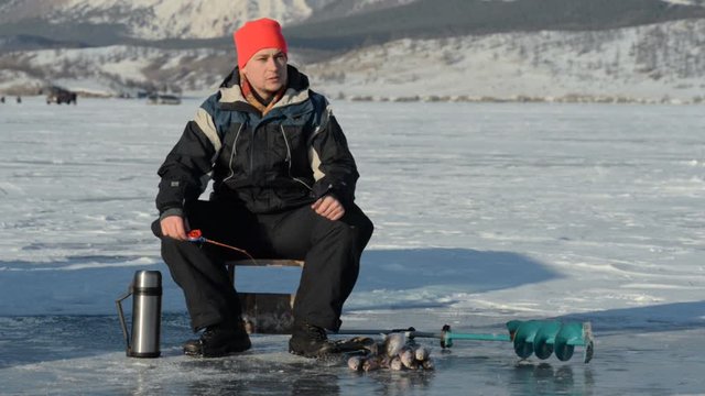 Fisherman is a man in winter fishing.