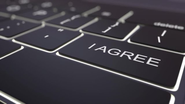 Dolly shot of black luminous computer keyboard and i agree key. Conceptual 4K clip