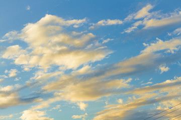 white fluffy clouds in the blue sky with sunset.