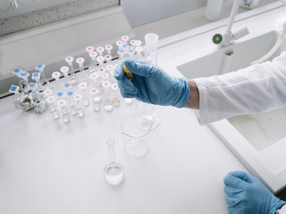 Fototapeta premium Chemist in gloves using her equipment