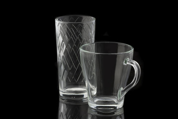 Transparent glass cup and glass on a black background