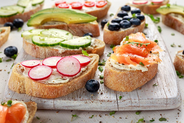 Homemade summer toast with cream cheese Smoked Salmon, Blueberries, Radish, Cucumber, Avocado and cress salad. Fresh healthy concept food.
