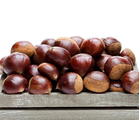 fresh  raw chestnuts in a wooden box isolated on white background