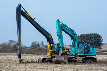 Two excavators stay after the hard work.