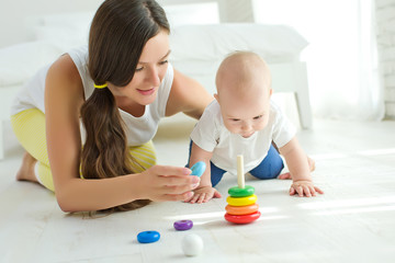 Obraz na płótnie Canvas Mom plays with the baby 