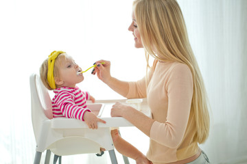 A woman is feeding a young child 