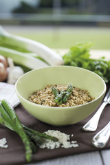 Risotto with Asparagus in ceramic vase on wooden chopping board