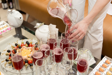 glasses with juice. catering. girl is pouring juice.
