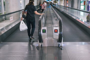 A girl walking on Automatic walkway at the airport.