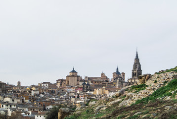 Fototapeta na wymiar A view to Toledo old town and Cathedral from a viewpoint over the hill at surroundings of the town, Castilla La Mancha, Sapin.