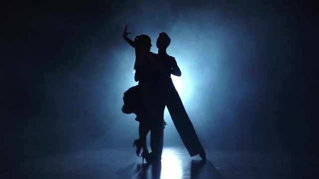 Silhouette of pair dancers performing rumba dance in slow motion