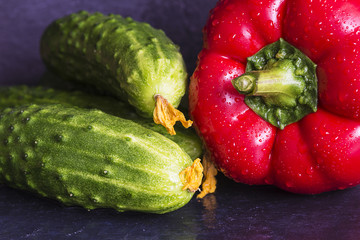 cucumbers and red sweet pepper on a slate
