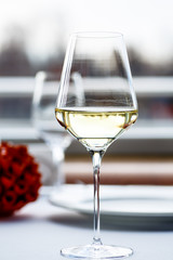 A glass of white wine stands on the table in the restaurant.