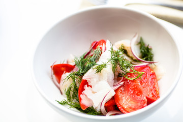 Salad of tomatoes onions and smoked halibut.