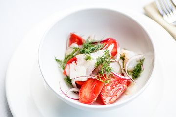 Salad of tomatoes onions and smoked halibut.