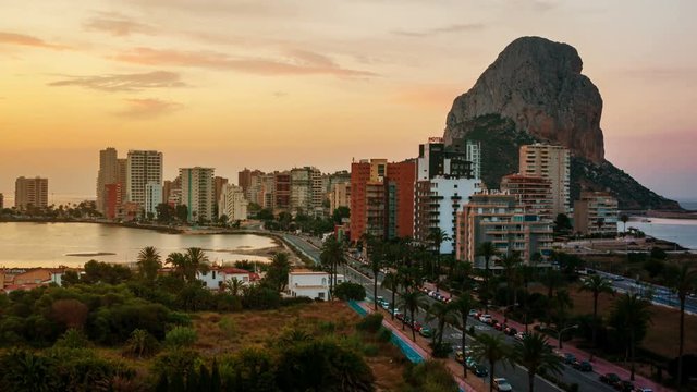 Calpe, Spain. Sunrise over the summer mediterranean resort Calpe in Costa Blanca, Spain. Aerial view of buildings, famous mountain Penon de Ifach and lake. Colorful sky, time-lapse from morning to day