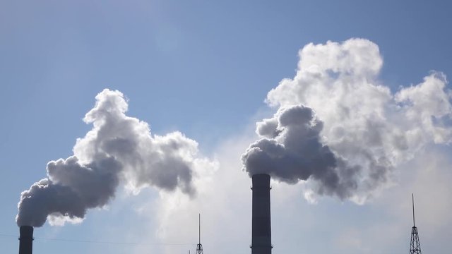 Air pollution from industrial chimneys spew clouds smoke in sky