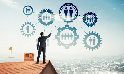 Businessman on house roof presenting teamwork and connection con