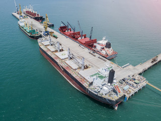 commercial vessel general cargo ship alongside of berth in port congestion for loading and discharging services in maritime transports in World wide logistics in aerial view