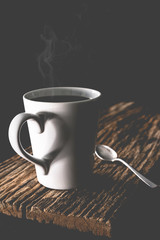 Coffee cup with steam set in low light background,Coffee in love concept.Matte style,vintage style.(Selective focus)