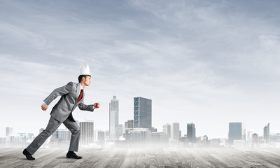 King businessman in elegant suit running and modern cityscape at background