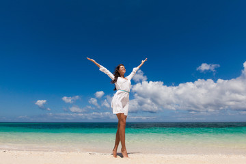 Woman with raised arms on beach