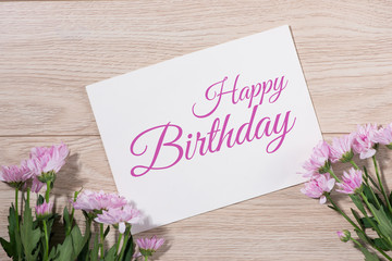 Pink flowers and empty paper for your text on wooden background © makistock
