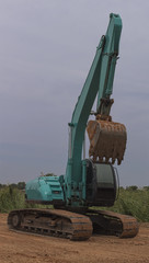 A Green Backhoe stand on ground