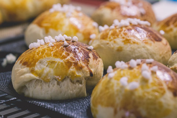 Freshly baked hot artisan bread buns beautifully golden straight out of the oven, cooling down