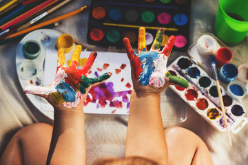 Painted colorful hands, soft focus background